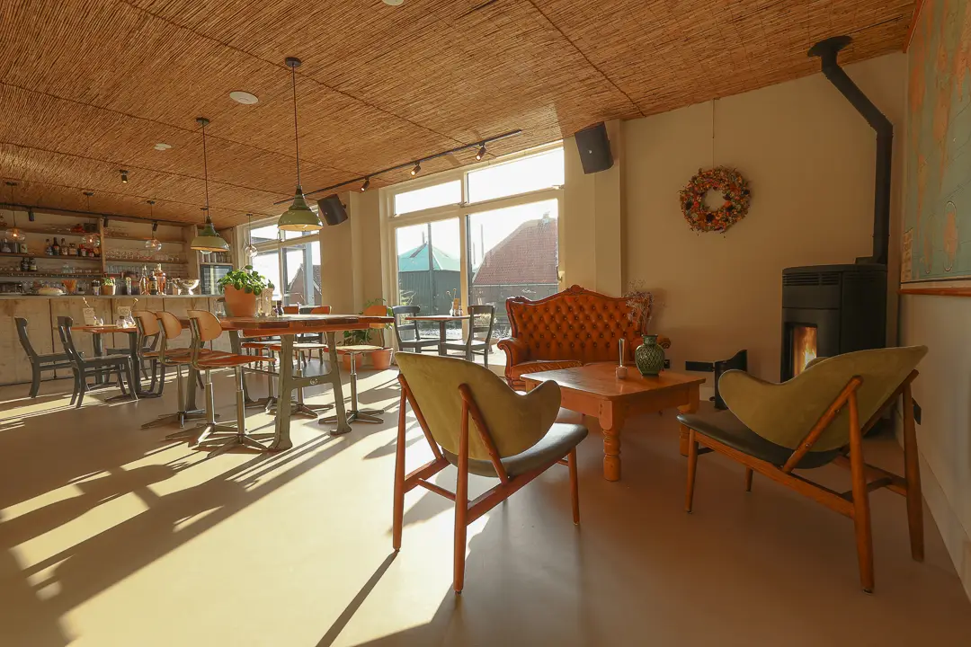 Zithoek met fauteuils en een houtkachel in het restaurant
